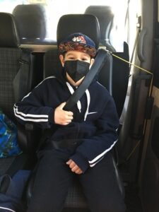 Junge mit Maske sitzt im Taxi