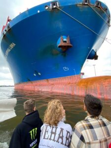 Schüler von hinten bestaunen Containerschiff