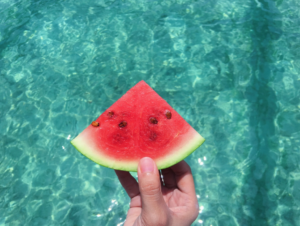 Melone gehalten vor Poolwasser