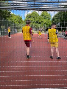 Zwei Jungs in gelbem Triot stehen auf Sportplatz