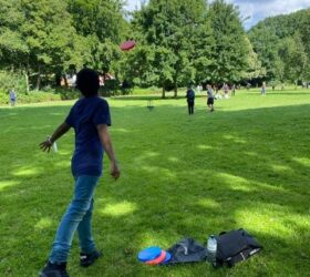 Junge wirft Frisbee Scheibe im Park