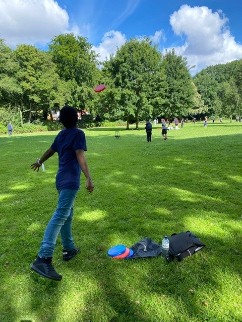 Junge wirft Frisbee Scheibe im Park