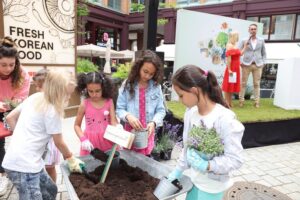 Mädchen bepflanzen Blumentöpfe mit frischer Erde