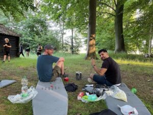 Gut Basthorst - Begleitpersonen sitzen auf Isomatte im Wald