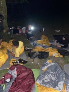 Gut Basthorst - Kinder liegen nachts im Wald, Junge mit Taschenlampe