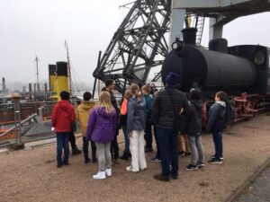 Die Klasse steht vor der Lokomotive der Hafenbahn im Hamburger Hafen