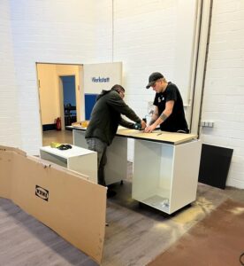 Mitarbeiter bauen die neue Küchenzeile von Ikea auf im Glücksgriff Lager