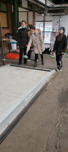 Mädchen wirft Eisstock auf Bahn in Alter Gleishalle