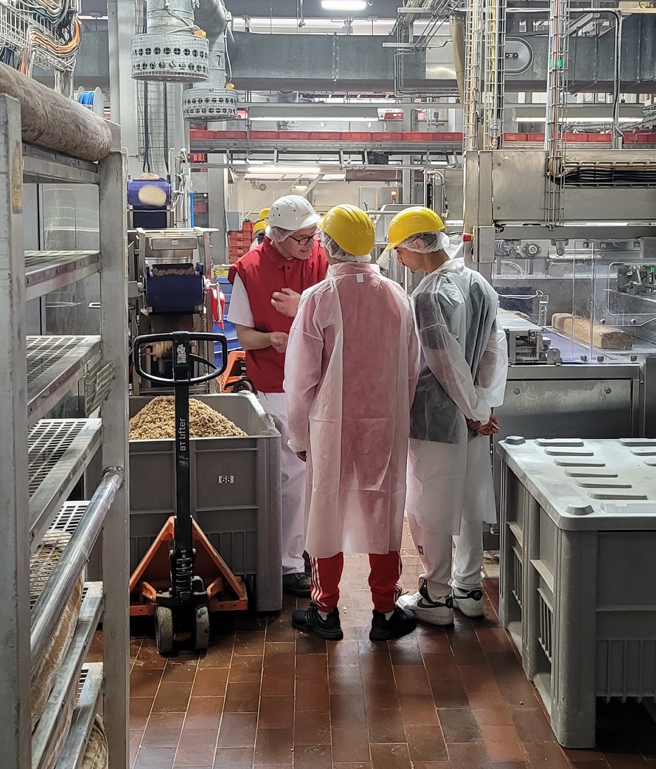 Schüler stehen vor Verschnitt in der Produktion bei Harry-Brot