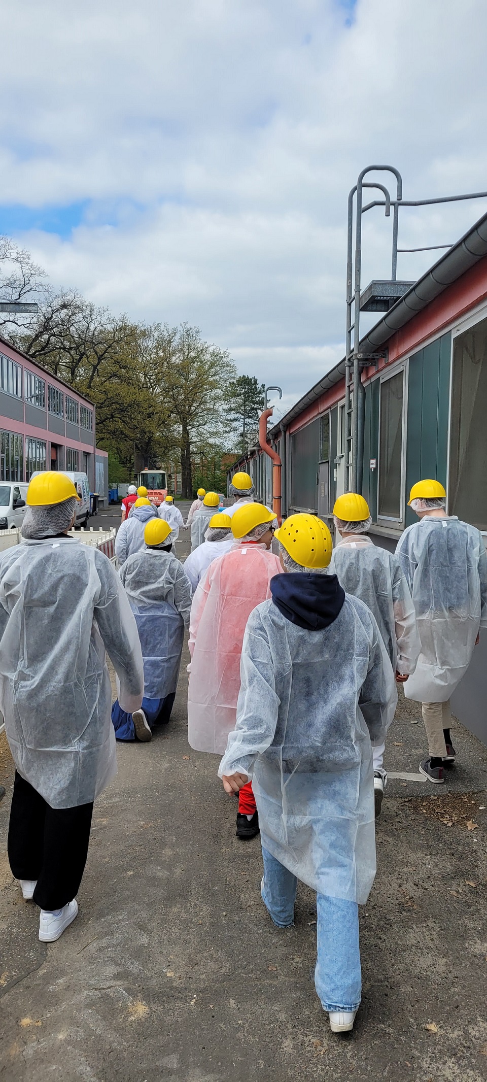 Schüler gehen über den Hof zur Produktionsstätte von Harry-Brot