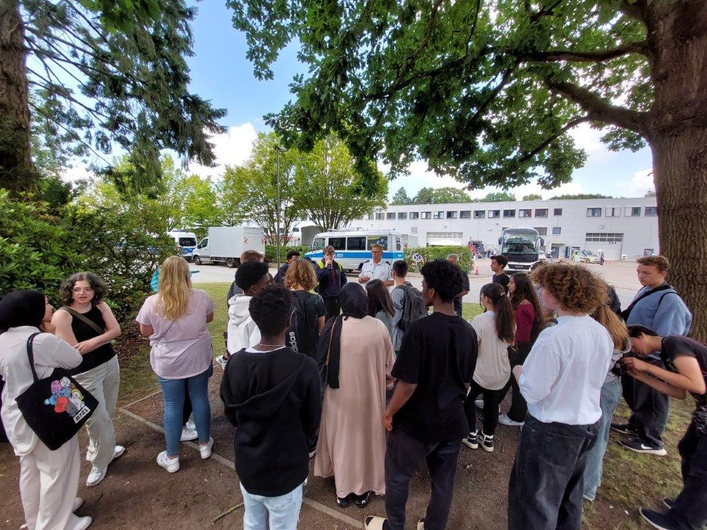 Schüler*innen stehen unter einem Baum beim Polizeimuseum