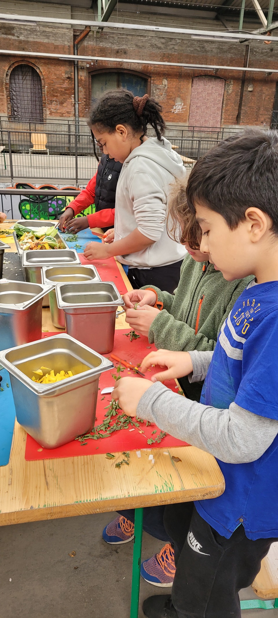Kinder zupfen Blätter vom Majoran ab in der Alten Gleishalle