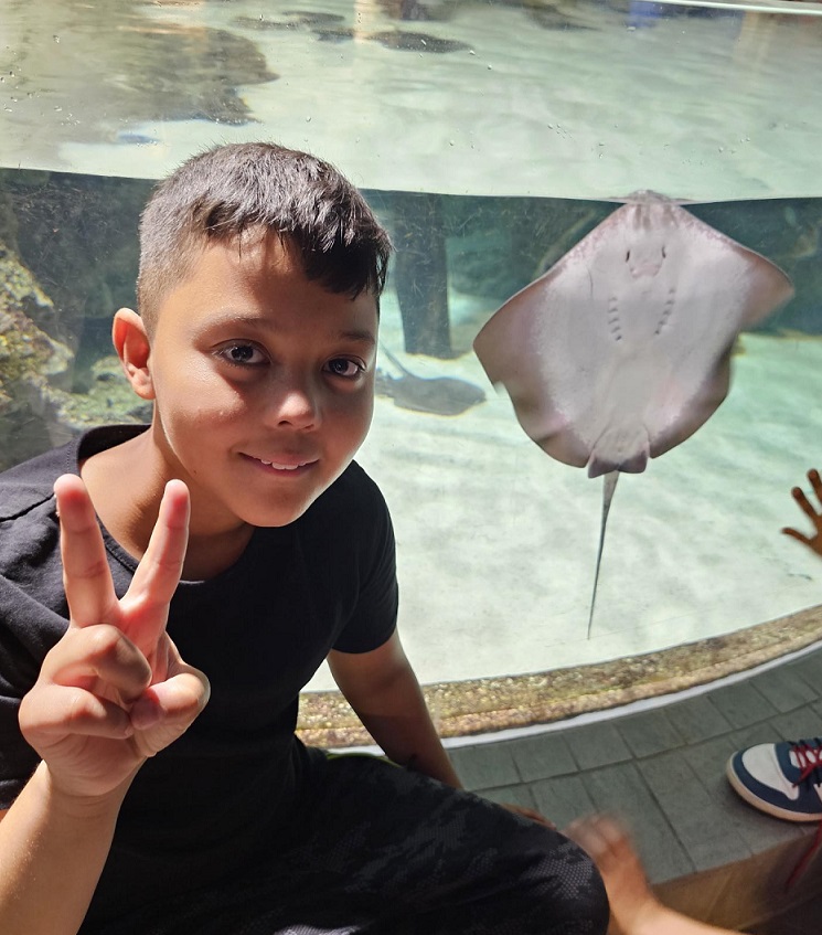 Junge mit Manta im Hintergrund im Tropen-Aquarium