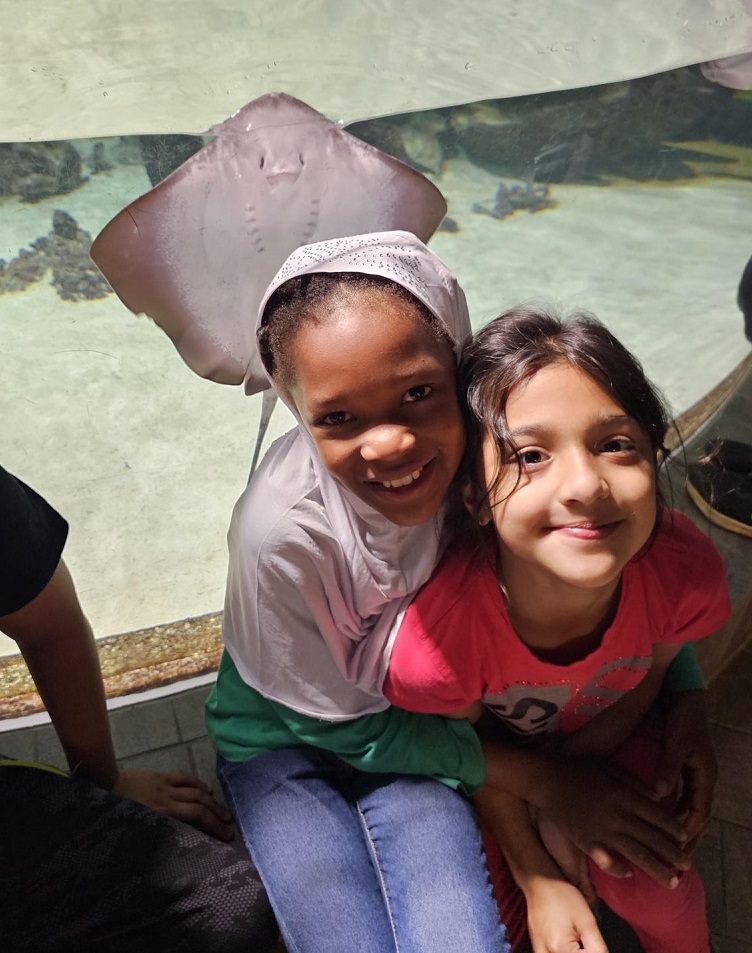 Mädchen mit Manta im Hintergrund im Tropen-Aquarium