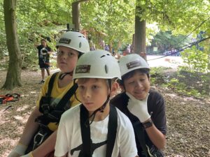 Drei Jungs mit Helm im Kletterpark
