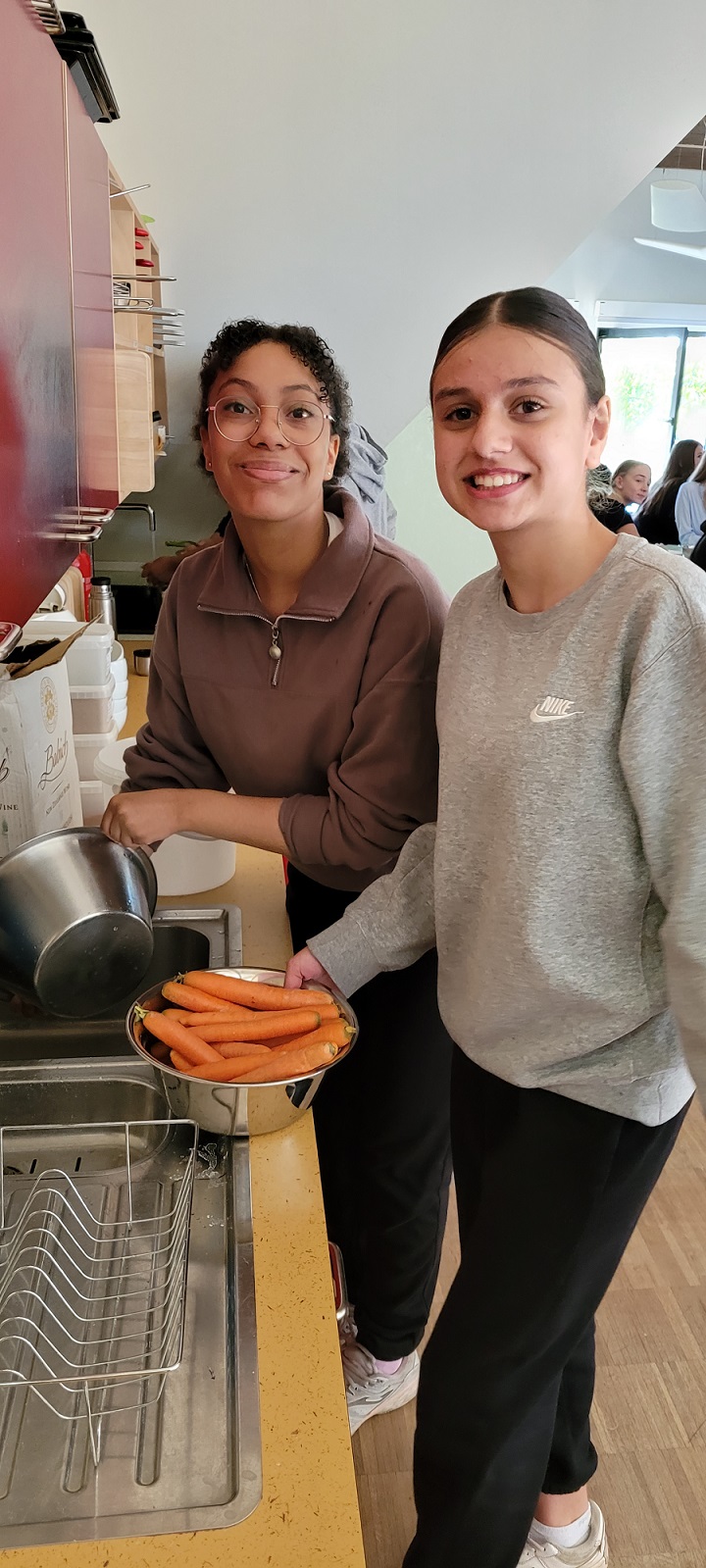 Zwei Schülerinnen waschen Möhren in der Küche der Forscher Werkstatt auf dem Gut Karlshöhe
