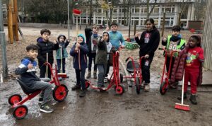 Kinder auf dem Schulhof mit neuen Fahrzeugen, bewegte Pause
