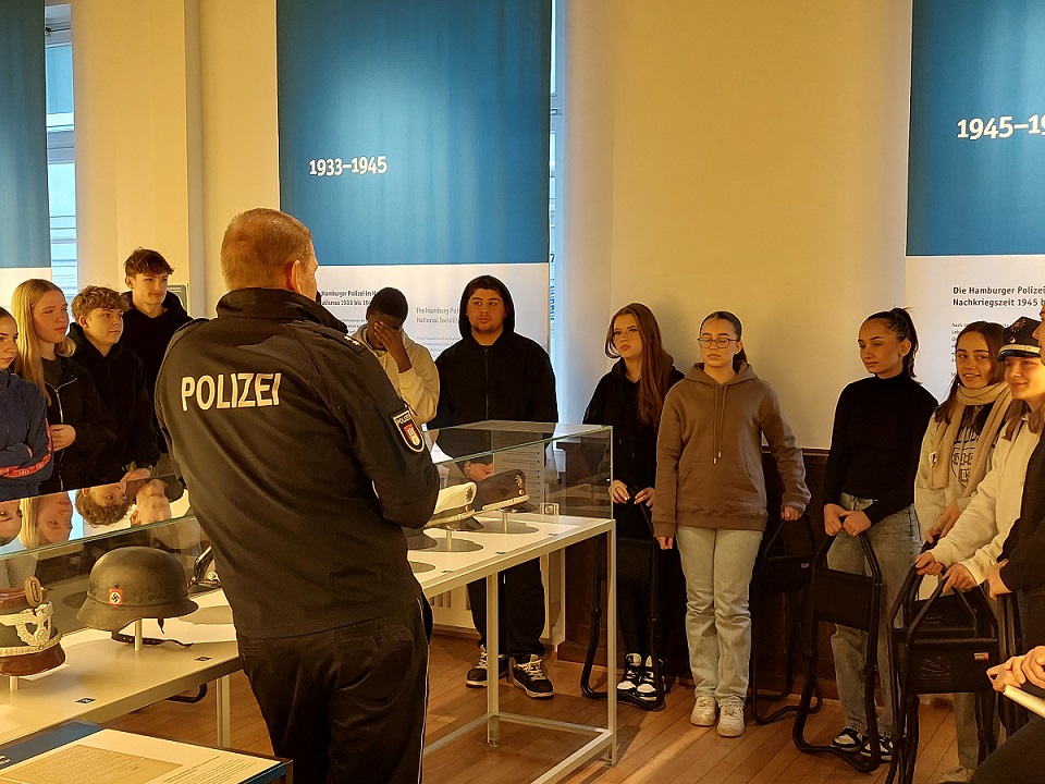 Schüler*innen horchen auf den Polizisten im Polizeimuseum